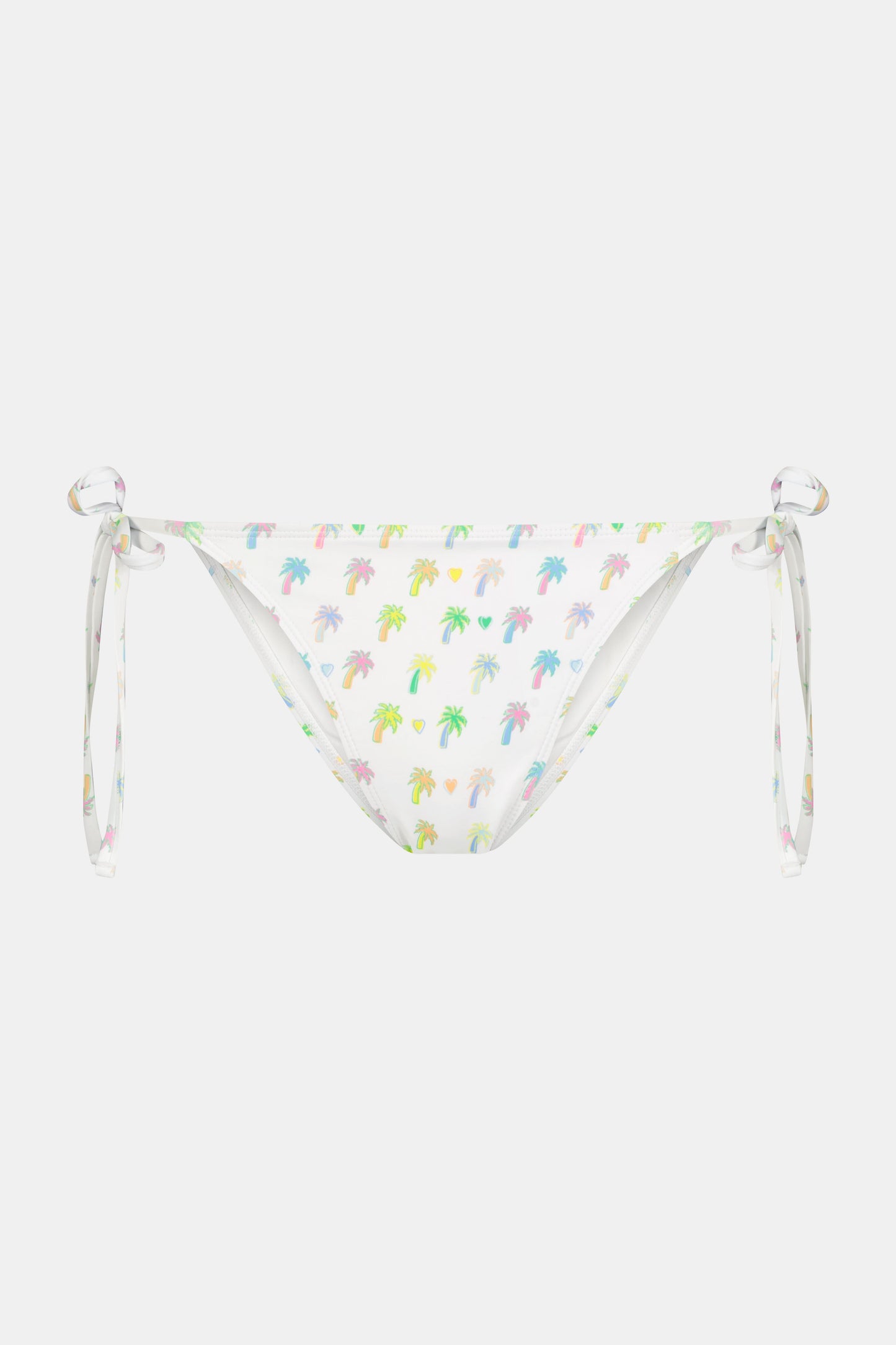 A person wears the Roller Rabbit Palm Dreams Serena Bikini Bottom, showcasing pastel palm trees and side ties, with one hand on their hip against a plain background.
