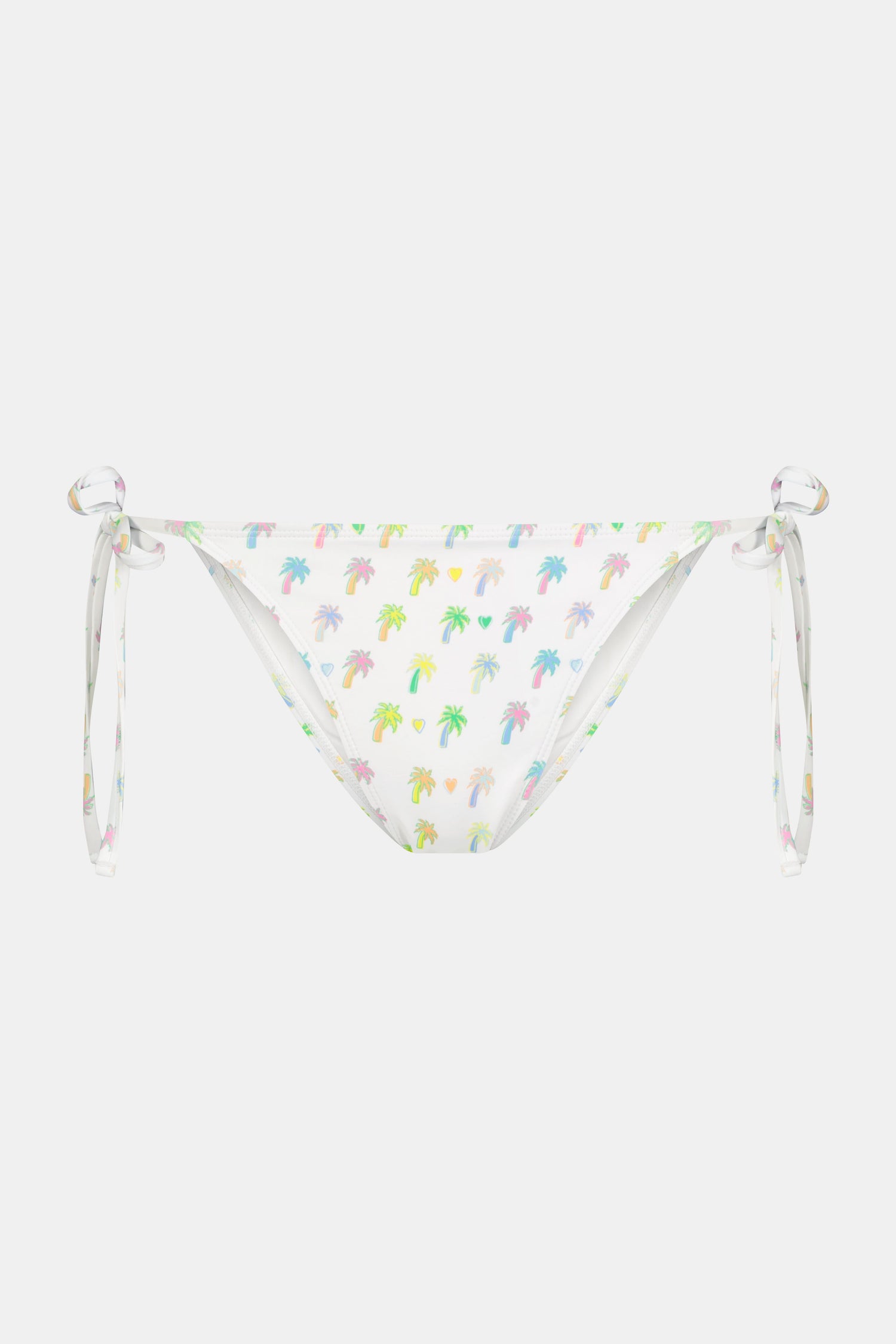 A person wears the Roller Rabbit Palm Dreams Serena Bikini Bottom, showcasing pastel palm trees and side ties, with one hand on their hip against a plain background.