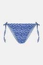 A person wears the Roller Rabbit Fish Stripe/Ruban Serena Bikini Bottom in blue with side ties, shown from torso to upper thighs against a plain white background. This bikini bottom offers UPF 50+ sun protection.