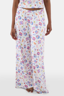 A person wears the Tinned or Twist Boden Pant—ultra-soft, loose white pajama pants featuring a colorful snack, drink, and food print—standing against a white background.