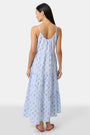 A woman with long hair stands facing forward, wearing the Roller Rabbit Wildflower Jemina Dakota Dress in sky blue and pink sandals.